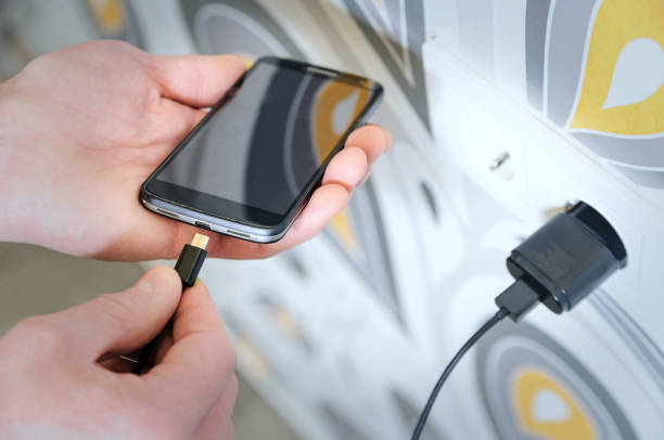 Seorang pria mengisi daya smartphone dengan teknologi fast charging, ilustrasi keamanan pengisian cepat